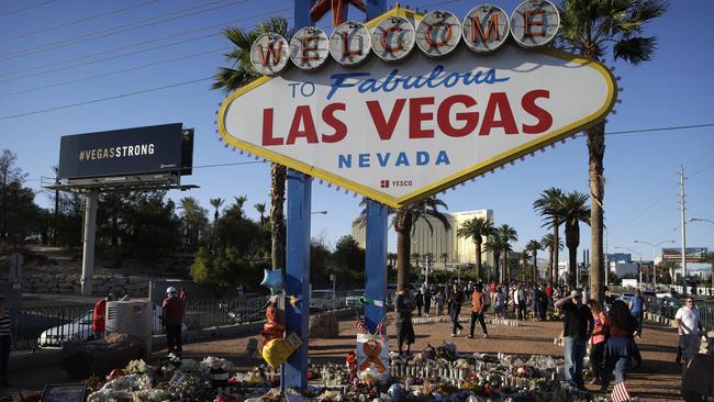 Flowers, candles and other items surround the famous Las Vegas sign at a makeshift memorial. Picture: AP