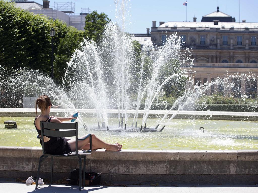 A woman sunbathes beside a fountain in the gardens of the “Palais Royal” in Paris on June 30, 2015. France is bracing for the thermometer to hit 39 degrees Celsius by the middle of the week, while Britain will have to contend with temperatures in the mid-30s. Picture: AFP