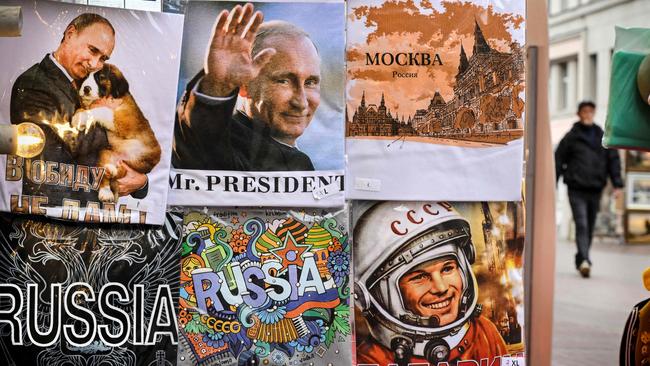 A man walks past t-shirts bearing images of Russian President Vladimir Putin and Yury Gagain, the first man in space, at a gift shop in downtown Moscow on October 6, 2022, on the eve of Vladimir Putin's 70th birthday.