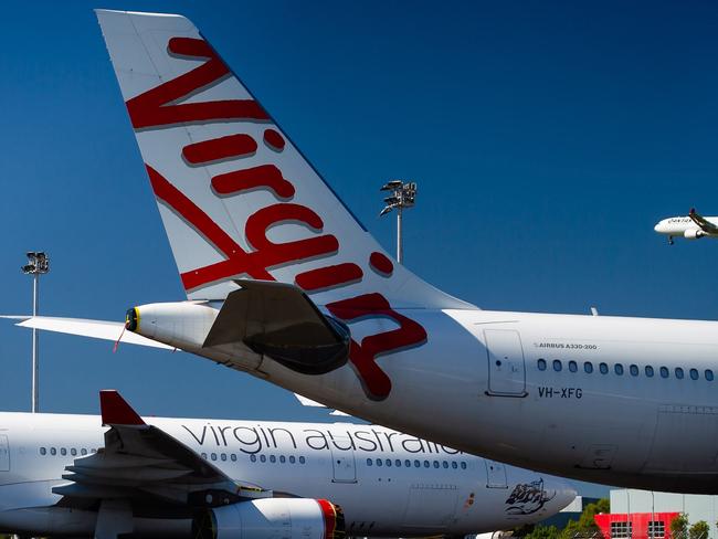 Virgin Australia aircraft are seen parked on the tarmac at Brisbane International airport on April 21, 2020. - Cash-strapped Virgin Australia collapsed on April 21, making it the largest carrier yet to buckle under the strain of the coronavirus pandemic, which has ravaged the global airline industry. (Photo by Patrick HAMILTON / AFP)