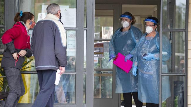 Staff talk to two visitors at the main entrance to the facility. Picture: Sarah Matray