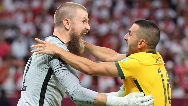 Australia's goalkeeper Andrew Redmayne (L) celebrates with Australia's defender Aziz Behich.