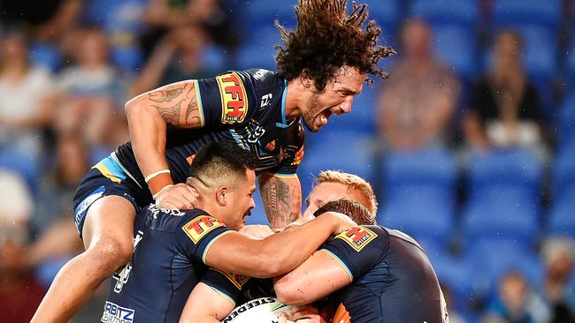 GOLD COAST, AUSTRALIA - SEPTEMBER 25: Kevin Proctor of the Titans jumps on the pack as AJ Brimson of the Titans celebrates with his team mates after scoring a try scoring a try during the round 20 NRL match between the Gold Coast Titans and the Newcastle Knights at Cbus Super Stadium on September 25, 2020 in Gold Coast, Australia. (Photo by Matt Roberts/Getty Images)