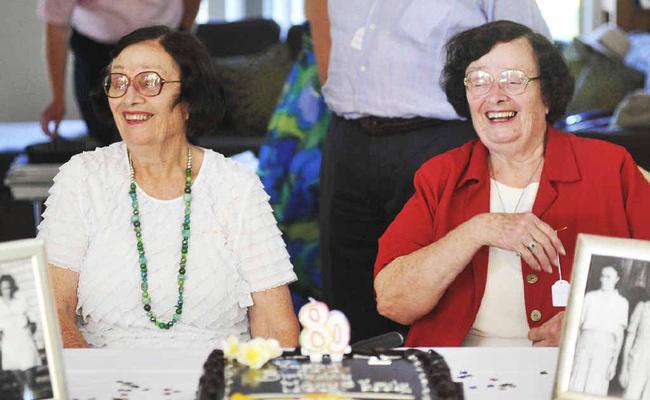 Mary and Emily (dressed in red) Betteridge celebrate their 80th birthday surrounded by friends acquired through their numerous fundraising events.