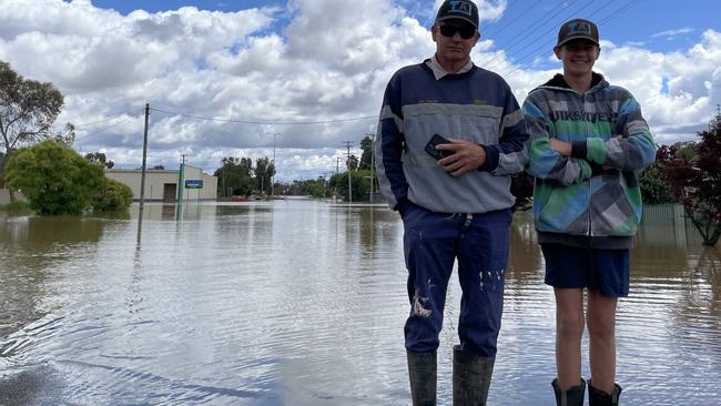 Gary and Jake Tomlinson survey the floodwaters outside their home in Forbes. Picture: Aymon Bertah