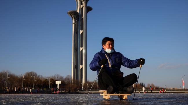 A man skates along a frozen canal near the closed loop bubble surrounding venues of the Winter Olympics in Beijing on Tuesday. Picture: Reuters