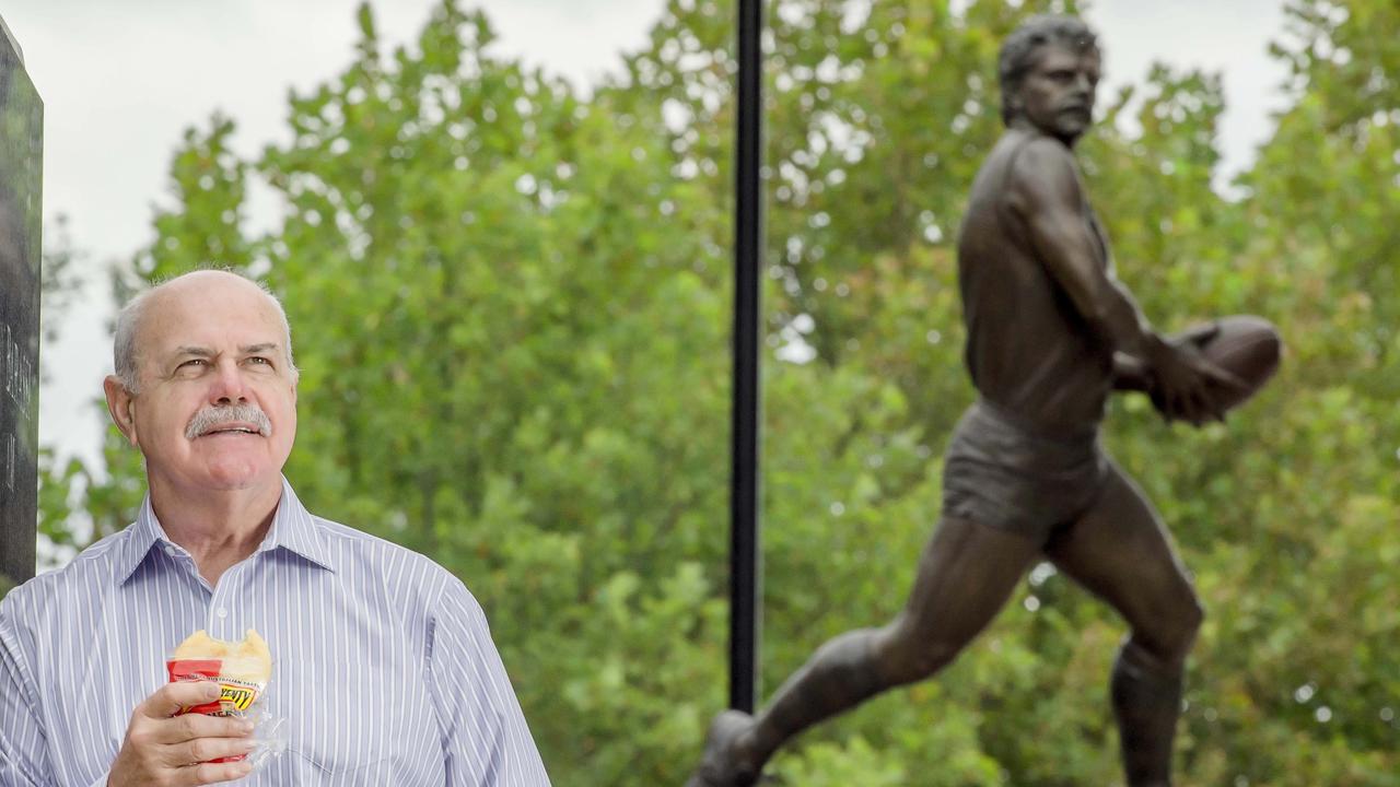 Matthews in front of his statue. Picture: Jason Edwards