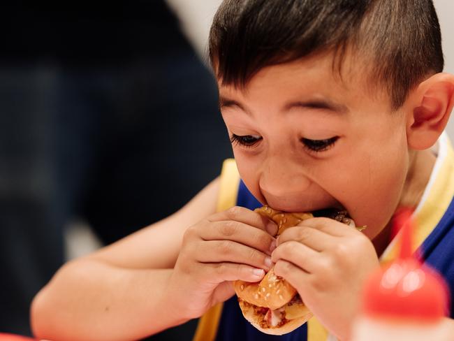 A boy tucks in at a Huxtaburger masterclass. Picture: Nicki Connolly