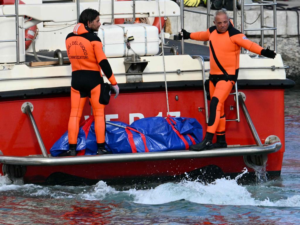 Divers arrive in Porticello harbour near Palermo, with a third body at the back of the boat, two days after the British-flagged luxury yacht Bayesian sank. Picture: Alberto Pizzoli/AFP