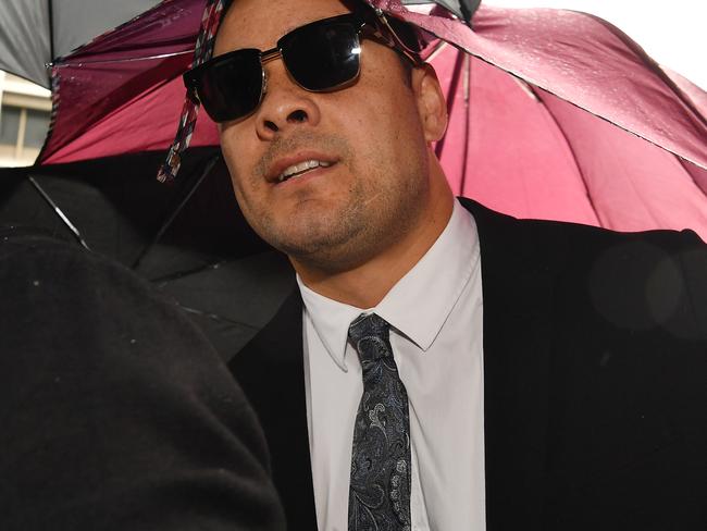 Several supporters of Jarryd Hayne shoved umbrellas in front of journalists as he walked in. Picture: Sam Mooy/Getty Images