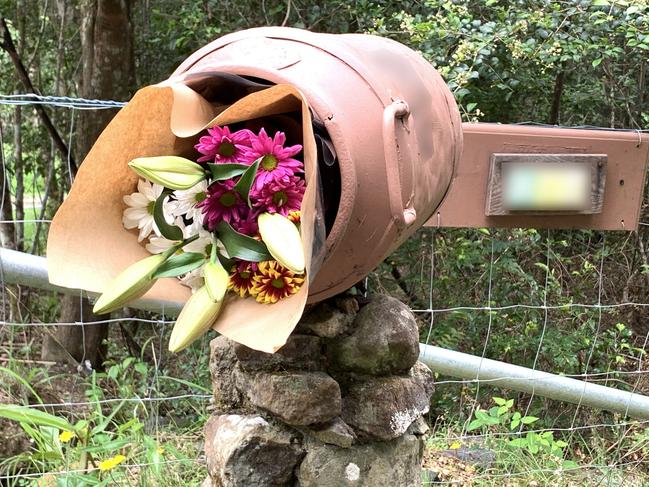 A floral tribute is left inside the letterbox where twin four-year-old girls died in a house fire at Goonengerry, NSW.