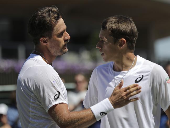 United States' Steve Johnson, left, greets Australia's Alex De Minaur at the net after beating him in a Men's singles match during day four of the Wimbledon Tennis Championships in London, Thursday, July 4, 2019. (AP Photo/Ben Curtis)