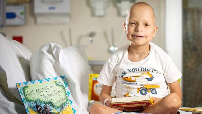 Xavier, 7, who had a liver transplant, loves to pass time with his Hairy Maclary books. Picture: Mark Stewart