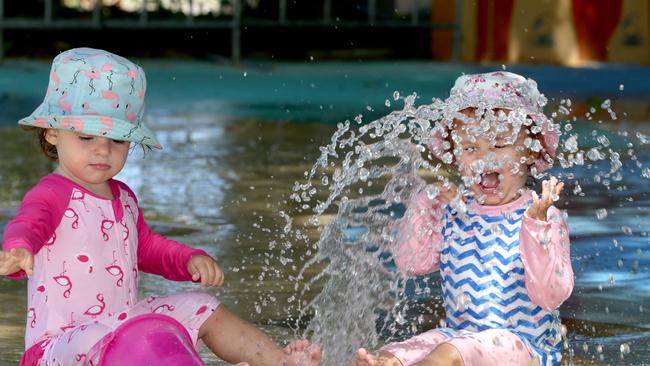 Toddlers Liselle Dunstan and Kyla Marshall play in the water at Muddy’s Playground in Cairns.
