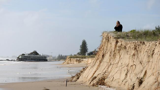 Early morning walkers watch the swell at Currumbin Alley as Cylone Alfred sits off the coast. Picture: Adam Head