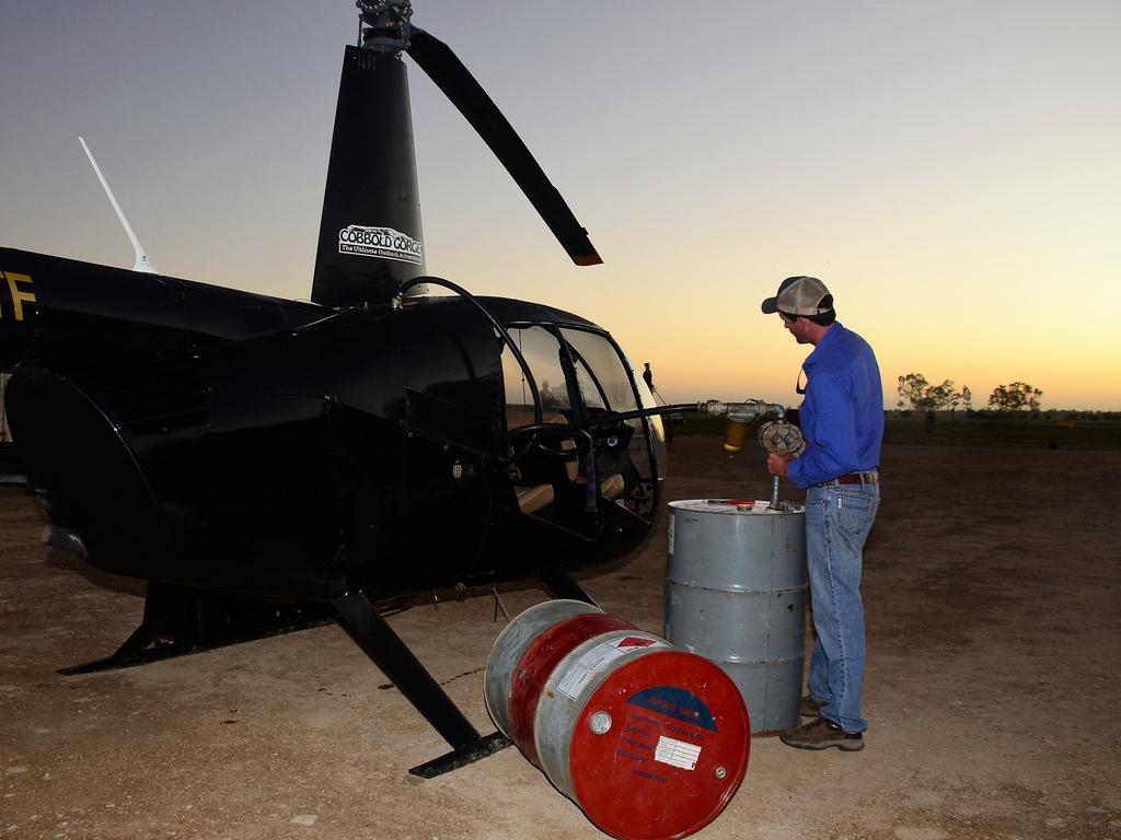 Flood relief helicopter pilot Harry Terry from Forsayth pumps fuel into his chopper before heading to Julia Creek. Picture: John Andersen