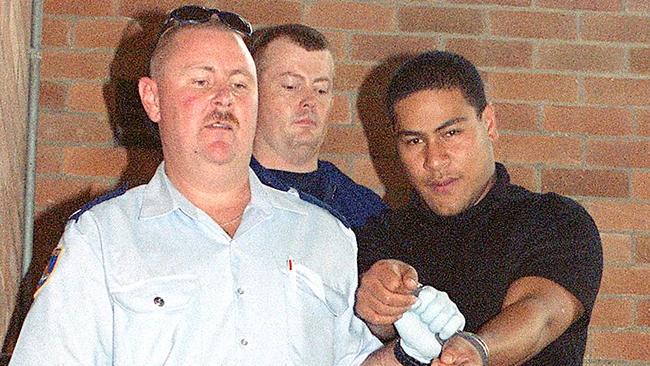 Sione Penisini being led away from court after being charged with the murder of policeman Glenn McEnallay in 2002. Picture: Mick Tsikas.