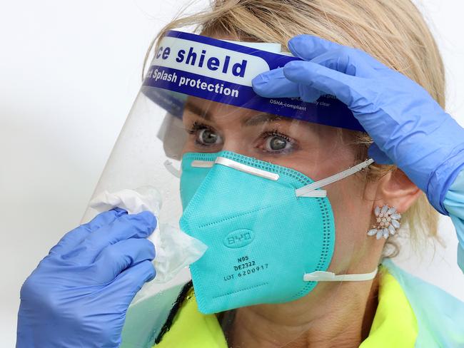 SYDNEY, AUSTRALIA - NewsWire Photos October 25, 2020: Pictured: Wearing rain gear is Registered Nurse Francee Drew wiping the rain off of her face shield at St VincentÃs Hospital Bondi Beach Covid testing site in Sydney, NSW. Picture: NCA NewsWire / Dylan Coker