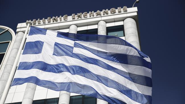 FILE - In this Feb. 3, 2015, file photo, a Greek flag flies outside the Athens Stock Exchange. In 2012, financial markets were rattled by the possibility Greece would elect a left-wing government, default on their debts and drop the euro currency. In 2015, the left-wing party, Syriza, holds power in Athens. Greece actually did miss a loan payment to the International Monetary Fund late Tuesday, June 30, 2015. And the nation's future in the eurozone hinges precariously on a referendum Sunday, July 5, 2015. (AP Photo/Petros Giannakouris, File)