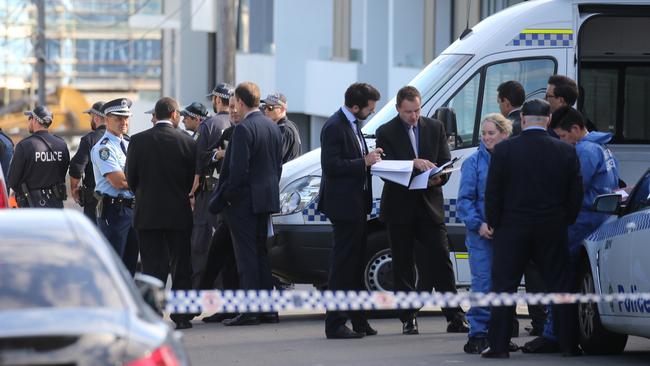 Police assemble outside the murder scene this morning. Picture: John Grainger