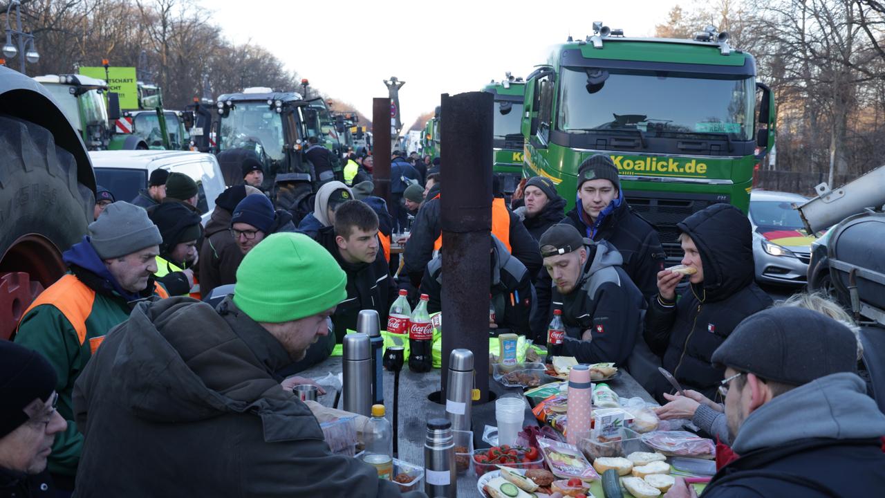 Protesting farmers eat breakfast among their tractors and trucks while blocking Street of 17 June in central Berlin. Picture: Sean Gallup/Getty Images