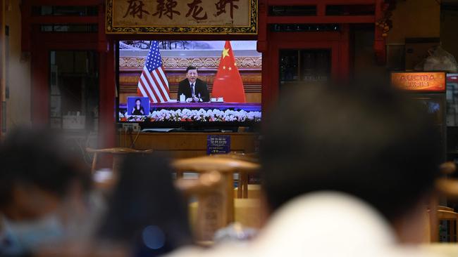 A television screen shows a news program about a virtual meeting between Xi Jinping and Joe Biden at a restaurant in Beijing. Picture: Jade Gao / AFP