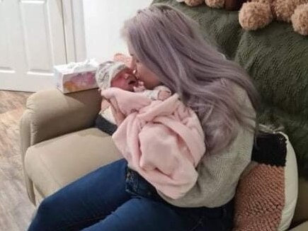 Nikki Hufton, 30, of Bahrs Scrub kisses her newborn daughter, Sophie, in the viewing room at Farewell Funerals in Meadowbrook before her cremation last year. Picture: Supplied