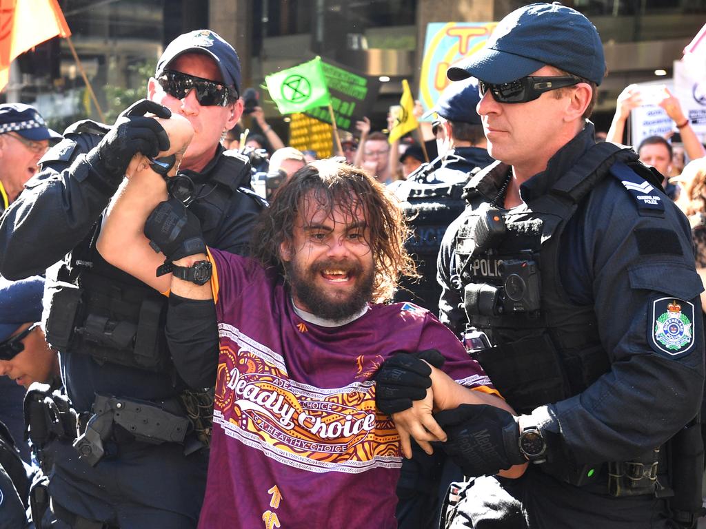 Police arrest a protester who was part of the action that blocked city streets in Brisbane. Picture: AAP