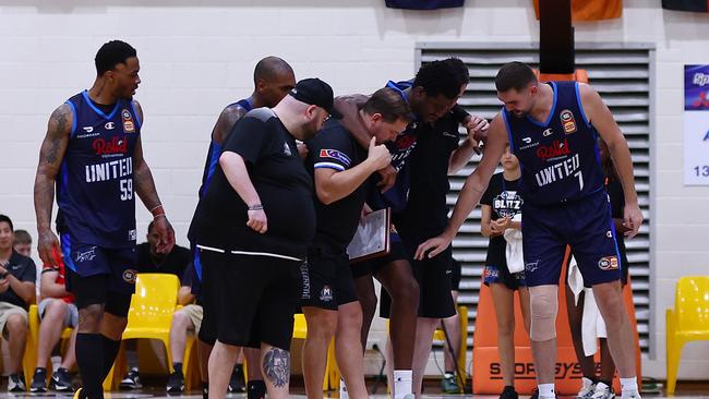 Hukporti of United (C) is helped from the court after suffering the injury. Picture: Getty