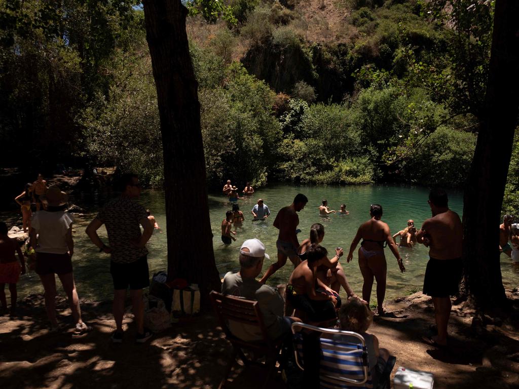 People enjoy the banks of the Guadiaro river at "La Cueva del Gato" near Benaojan, in southern Spain. Picture: AFP