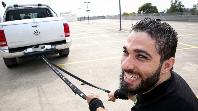 Moustafa Ardati shows how he will pull the two-tonne ute. Picture: Carmela Roche