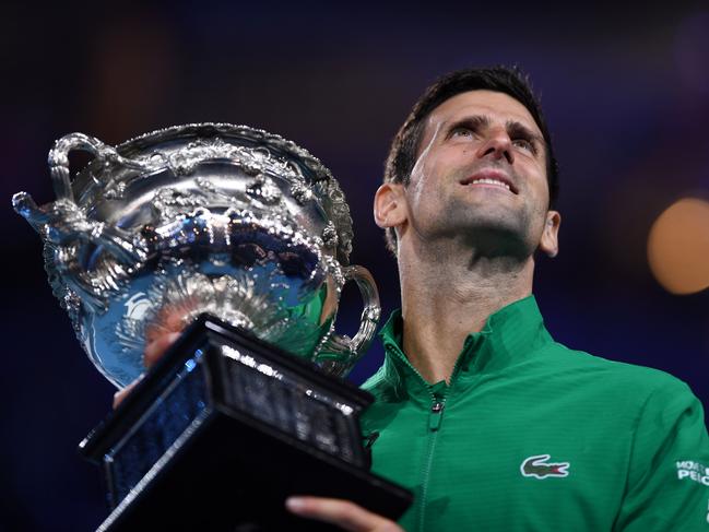 TOPSHOT - Serbia's Novak Djokovic holds the Norman Brookes Challenge Cup trophy after beating Austria's Dominic Thiem in their men's singles final match on day fourteen of the Australian Open tennis tournament in Melbourne on February 3, 2020. (Photo by Saeed KHAN / AFP) / IMAGE RESTRICTED TO EDITORIAL USE - STRICTLY NO COMMERCIAL USE