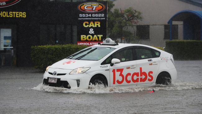 Major flooding in Currumbin Creek rd at Currumbin. Traffic sends waves through shops and factories. Someone called a cab? Picture: Glenn Hampson