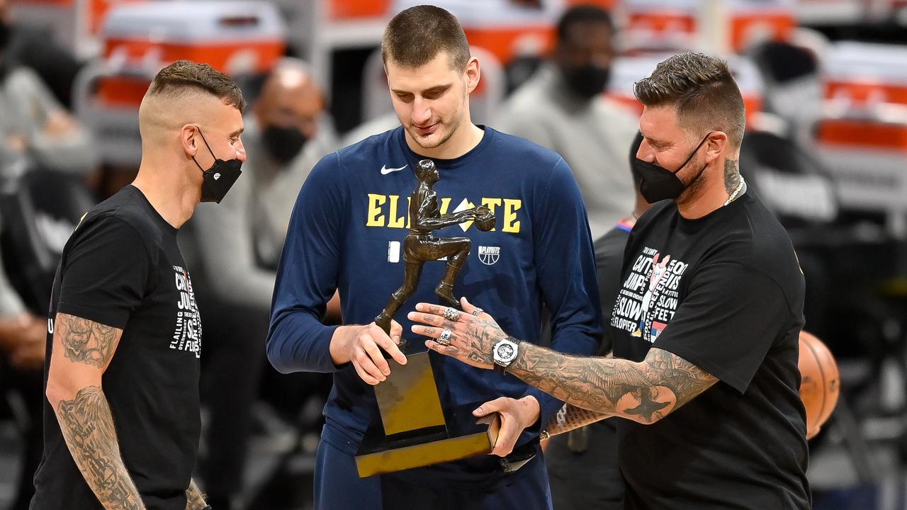Nikola Jokic #15 of the Denver Nuggets accepts congratulations from his brothers after being awarded the 2021 NBA MVP award.