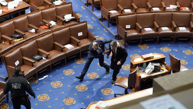 Members of congress run for cover as protesters enter the House Chamber during a joint session of Congress.