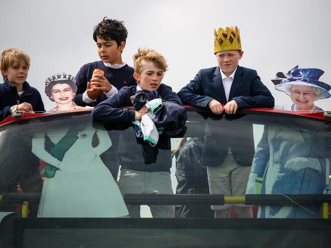 Cardboard cutouts depicting Queen Elizabeth II during two different periods of her reign are seen on the top of a decorated bus, as racegoers prepare for the days events in Epsom. Picture: Getty Images