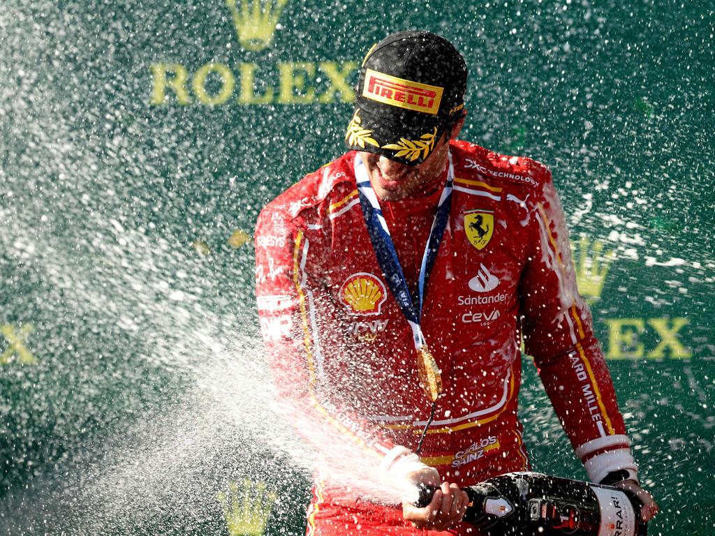 Ferrari's Spanish driver Carlos Sainz Jr sprays champagne to celebrate victory on the podium after the Australian Formula One Grand Prix at Albert Park Circuit in Melbourne on March 24, 2024. (Photo by Martin KEEP / AFP) / — IMAGE RESTRICTED TO EDITORIAL USE – STRICTLY NO COMMERCIAL USE —