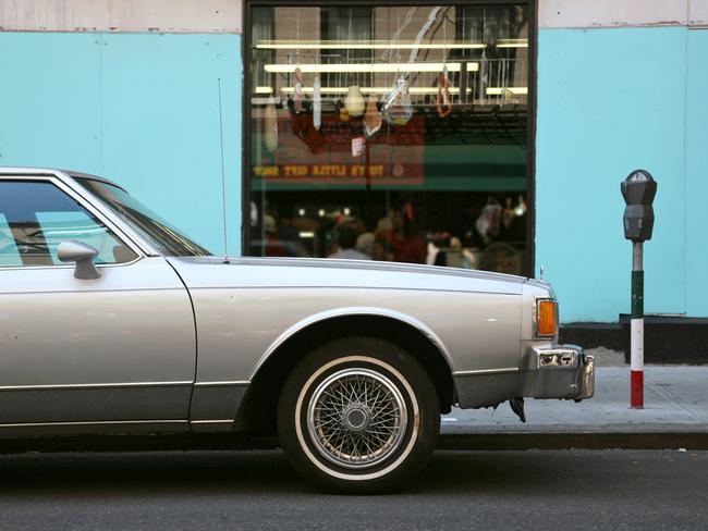 An old sedan car parked outside an Italian delicatessen in Little Italy, New York City, New York, USA.