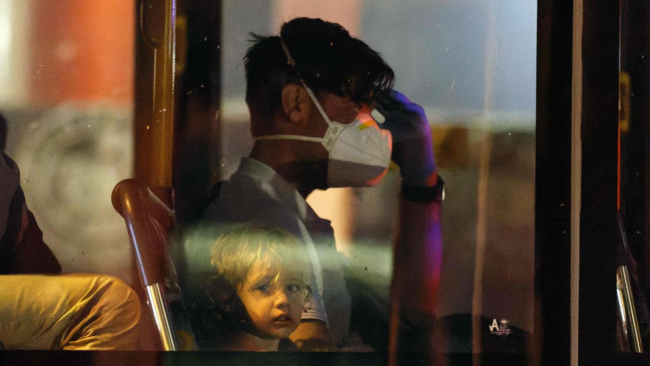 A young child and a man, part of around 90 Australian citizens and Afghan nationals who were evacuated from Afghanistan arriving in Perth on Friday. Picture: TREVOR COLLENS / AFP.