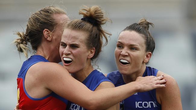 Greta Bodey celebrates a goal with her Brisbane teammates Lauren Arnell and Emily Bates.