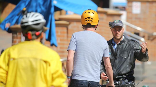 A NSW police officer issues a fine for jaywalking. Picture: John Grainger