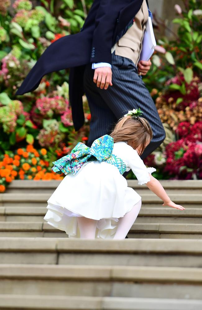 Bridesmaid Princess Charlotte of Cambridge falls on the steps as she arrives to take part in the wedding. Picture: AFP