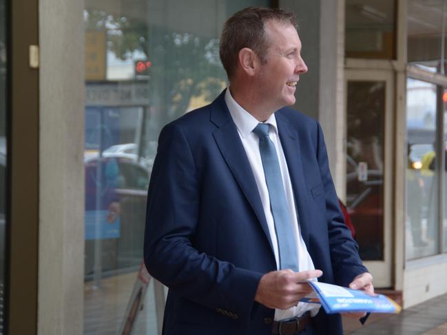 Groom MP Garth Hamilton hands out how-to-vote cards outside the federal election early voting centre in the Toowoomba CBD.