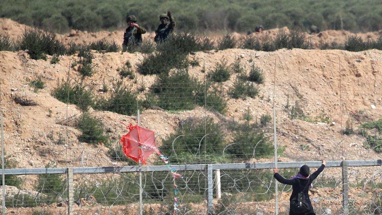 A Palestinian woman tries to fly a kite next to the Israeli border. Picture: AFP