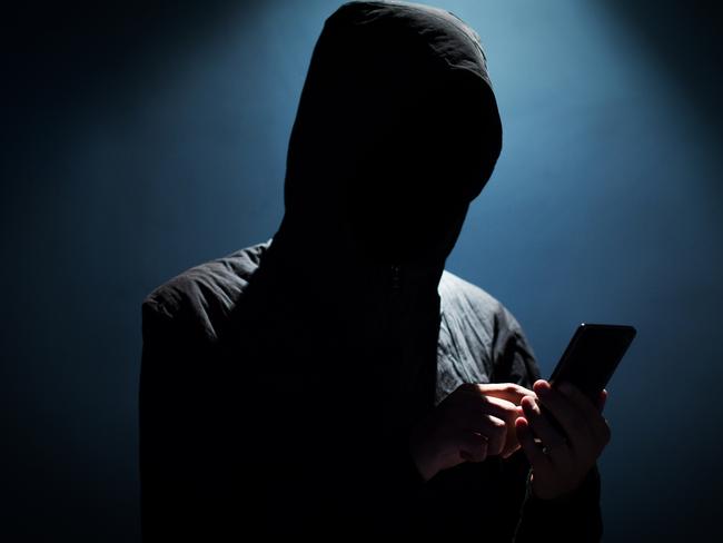 Hacker holding phone istock image