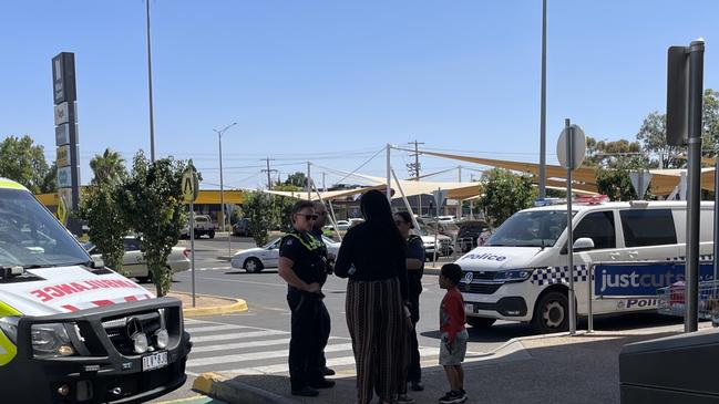 Paramedics and police talk to Mum after the kids have been checked out and given the all clear after being locked in the car for what onlookers say was up to 40 minutes..