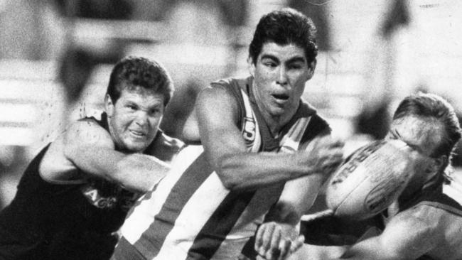 Darren Jarman gets a handball away for North Adelaide in 1987.