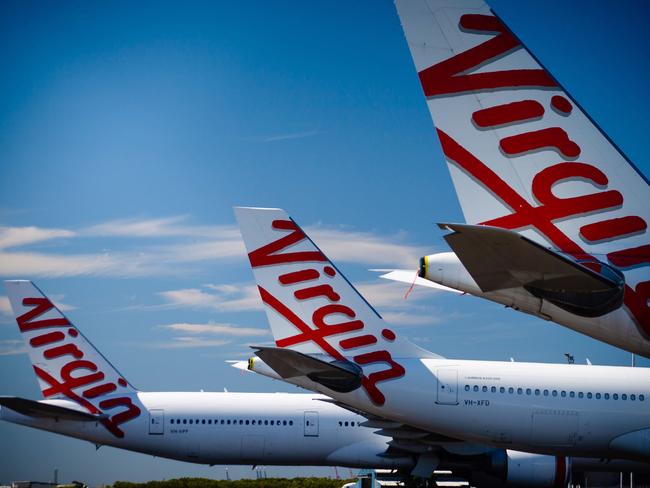 Virgin Australia aircraft are seen parked on the tarmac at Brisbane International airport on April 21, 2020. - Cash-strapped Virgin Australia collapsed on April 21, making it the largest carrier yet to buckle under the strain of the coronavirus pandemic, which has ravaged the global airline industry. (Photo by Patrick HAMILTON / AFP)