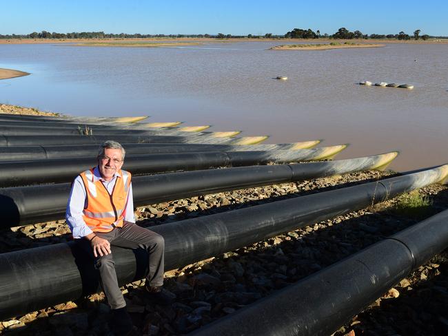 Fluid effect: Claudio Cavallini beside the 19.5ha storage dam and the pipes through which water is pumped to irrigate the trees on the Riverina farms.