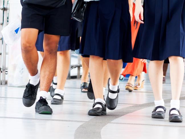 Capture of feet and shoes of students in school uniform and leaving shopping mall and walking over pedestrian bridge.